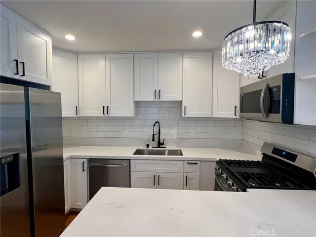 a kitchen with stainless steel appliances a sink stove and refrigerator