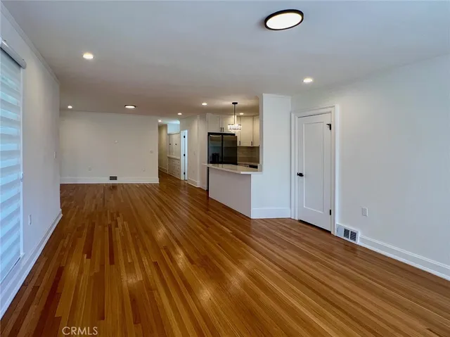 a view of a room with wooden floor and a sink