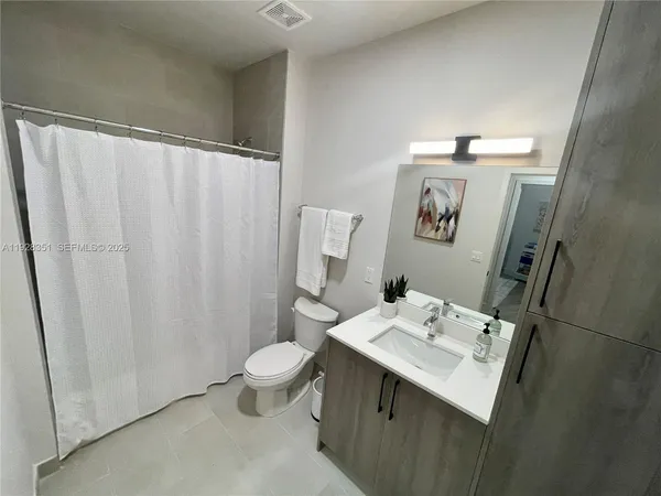 a bathroom with a sink a toilet and shower curtain