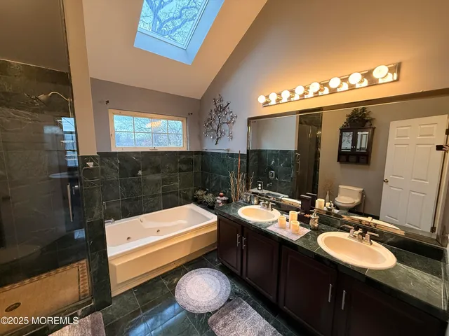 a bathroom with a sink a toilet a mirror and shower