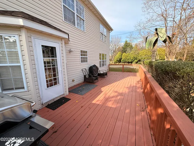 a view of a house with a barbeque and wooden floor