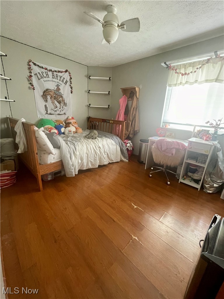 7990 Quarry Road Amherst, OH 44001 - Photo 19 of 29 Unfurnished bedroom with ceiling fan, a textured ceiling, and hardwood / wood-style flooring