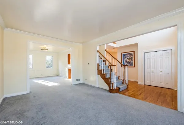 a view of an empty room with stairs and a window