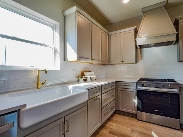 a kitchen with stainless steel appliances a sink stove and cabinets
