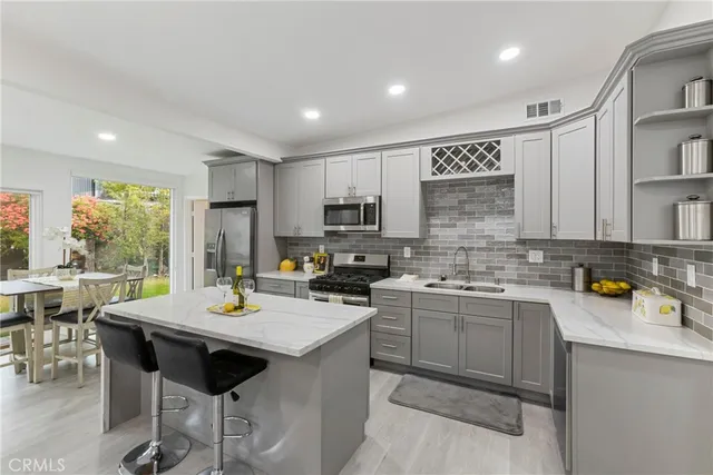 a kitchen with stainless steel appliances a sink stove and cabinets