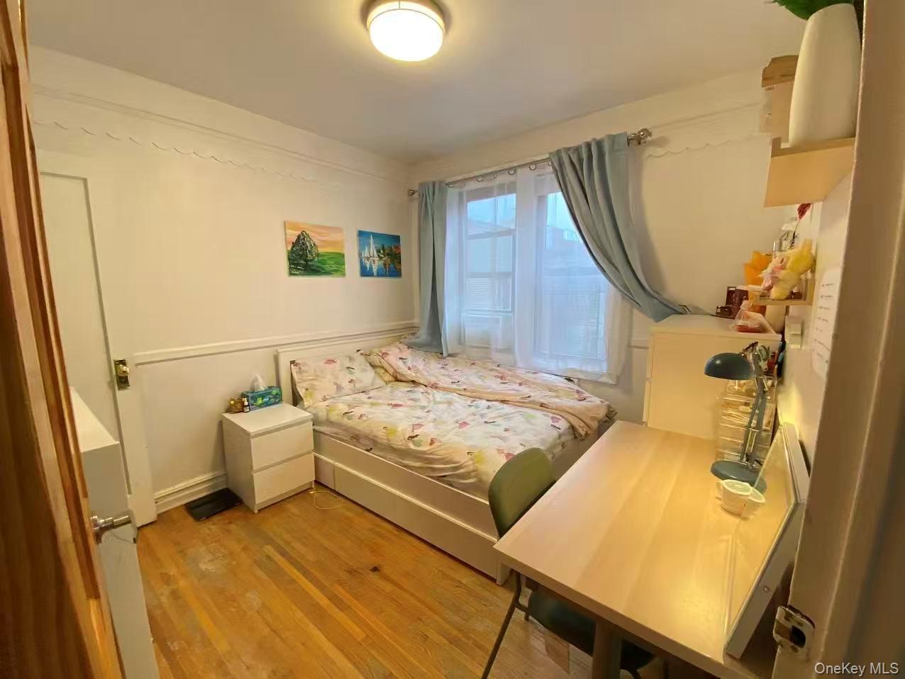 42-52 Layton Street, Unit 6F Queens, NY 11373 - Photo 4 of 10 a bedroom with a bed and wooden floor