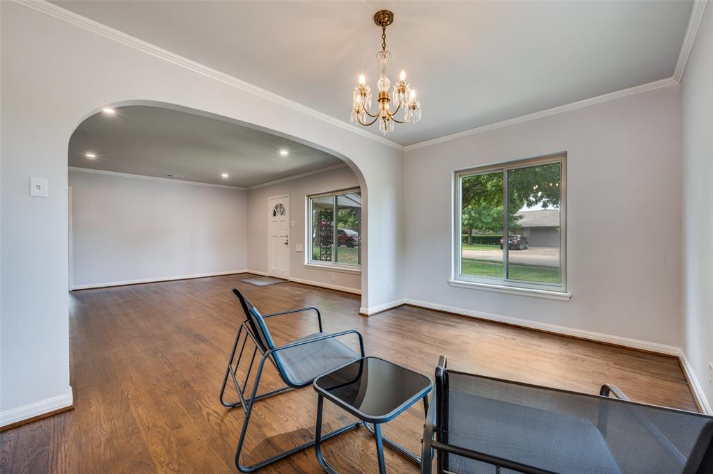 1342 Michigan Avenue Dallas, TX 75216 - Photo 11 of 25 Unfurnished dining area with arched walkways, crown molding, wood finished floors, and a chandelier
