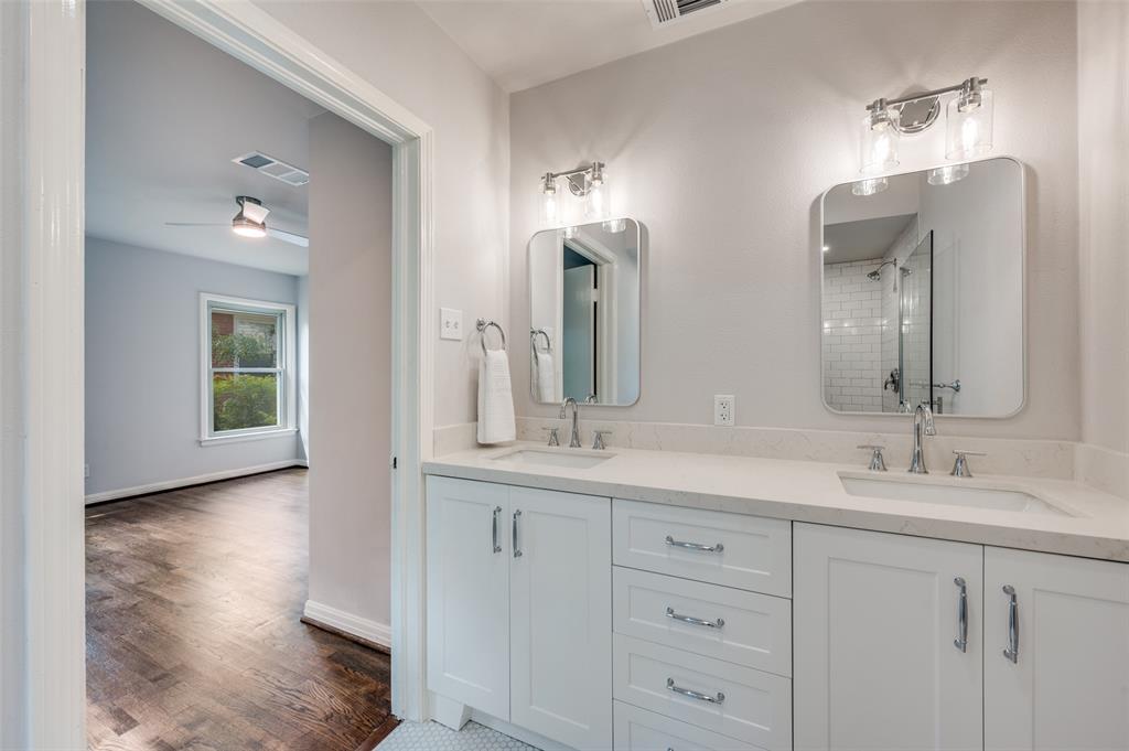 1342 Michigan Avenue Dallas, TX 75216 - Photo 20 of 25 Bathroom featuring double vanity, a tile shower, dark wood-style flooring, and a ceiling fan