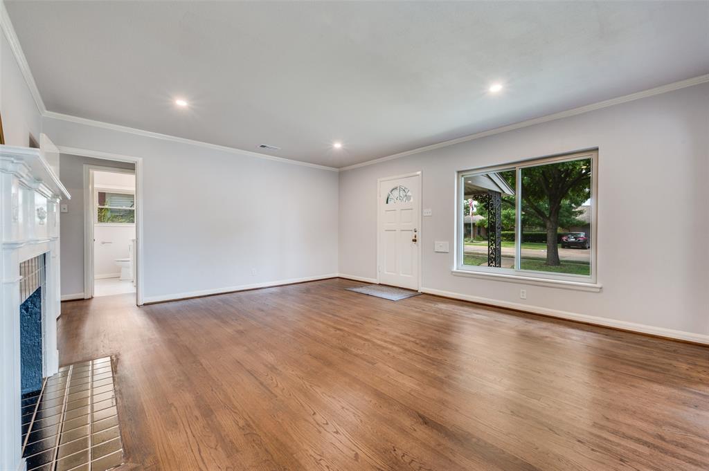 1342 Michigan Avenue Dallas, TX 75216 - Photo 7 of 25 Unfurnished living room featuring ornamental molding, a brick fireplace, wood finished floors, and recessed lighting