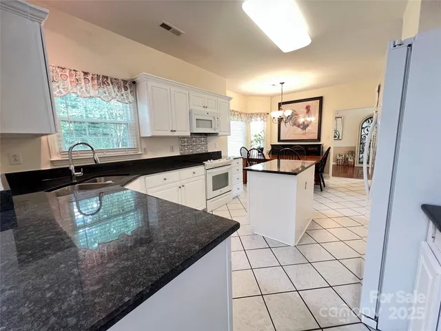 a kitchen with stainless steel appliances a stove a sink and a refrigerator