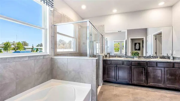a bathroom with a granite countertop sink and a bathtub