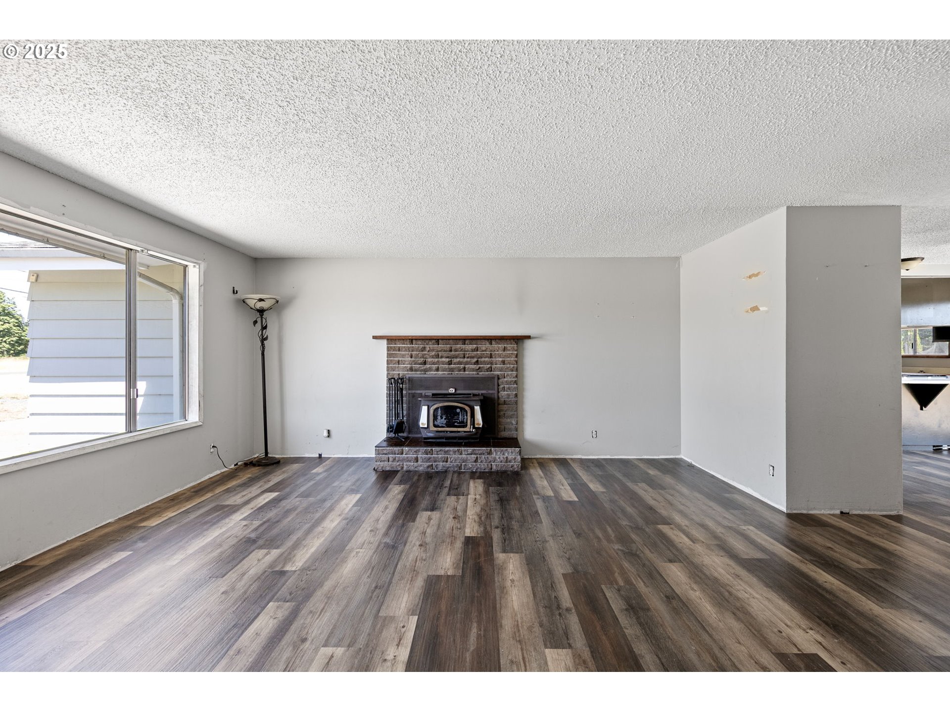 34879 Seavey Loop Road Eugene, OR 97405 - Photo 4 of 34 a view of an empty room with a fireplace and a window