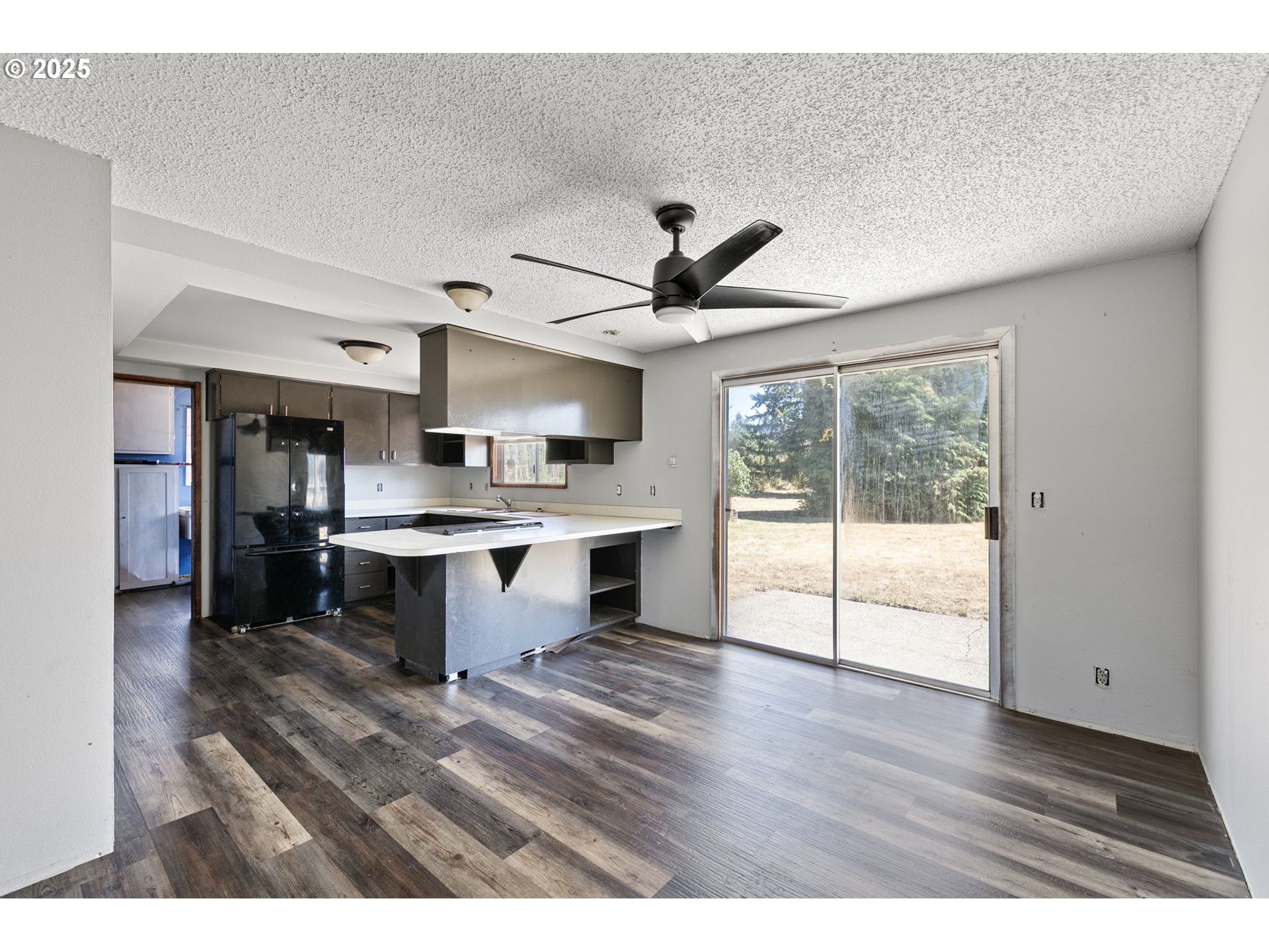 34879 Seavey Loop Road Eugene, OR 97405 - Photo 7 of 34 a open kitchen with stainless steel appliances granite countertop a stove top oven a sink with white cabinets and wooden floor