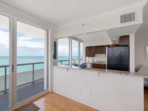 a kitchen with stainless steel appliances kitchen island granite countertop a refrigerator and a sink
