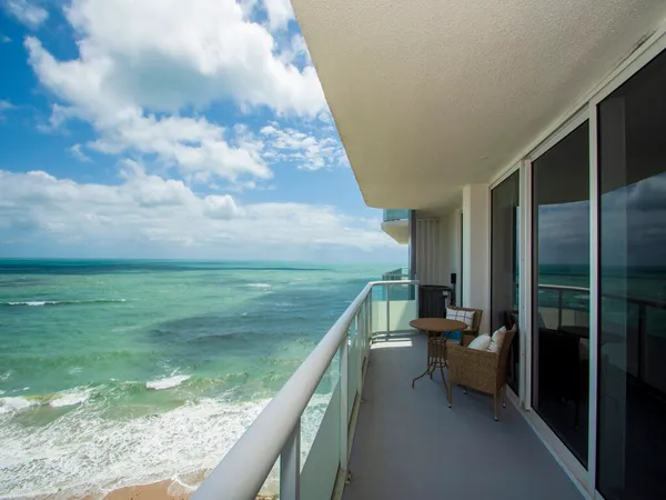 a living room with furniture a floor to ceiling window and a flat screen tv
