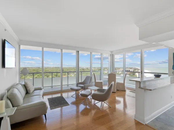 a living room with furniture and floor to ceiling windows
