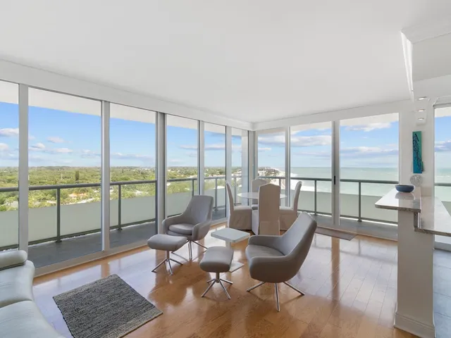 a view of a livingroom with furniture and floor to ceiling window