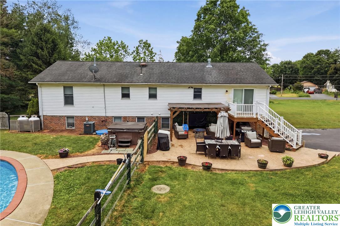 732 Bushkill Center Road Nazareth, PA 18064 - Photo 33 of 43 A spacious backyard retreat features a shimmering pool, hot tub, and an inviting outdoor patio perfect for relaxation and entertaining.