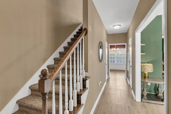 a view of a hallway with wooden floor and entryway