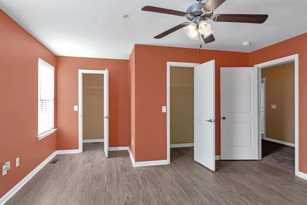 a view of an empty room with window and wooden floor