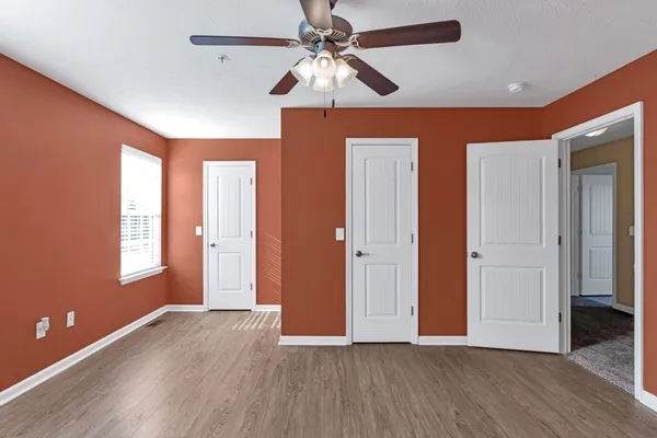 a view of an empty room with window and wooden floor