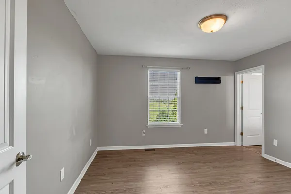 an empty room with windows and closet