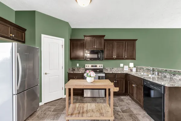 a kitchen with stainless steel appliances a sink stove and refrigerator