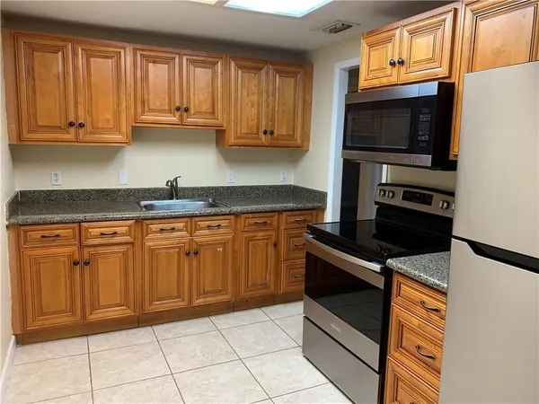 a kitchen with granite countertop a stove and a microwave