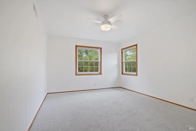 a view of a house with a yard and potted plants