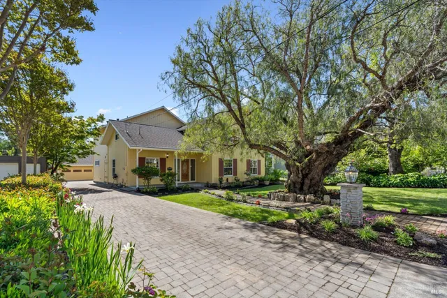 a front view of a house with a yard and potted plants