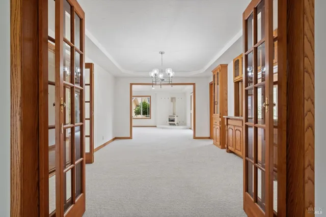 a view of a room with chandelier front door and windows