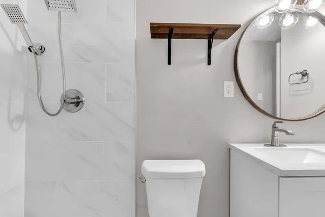a bathroom with a sink a toilet and a mirror