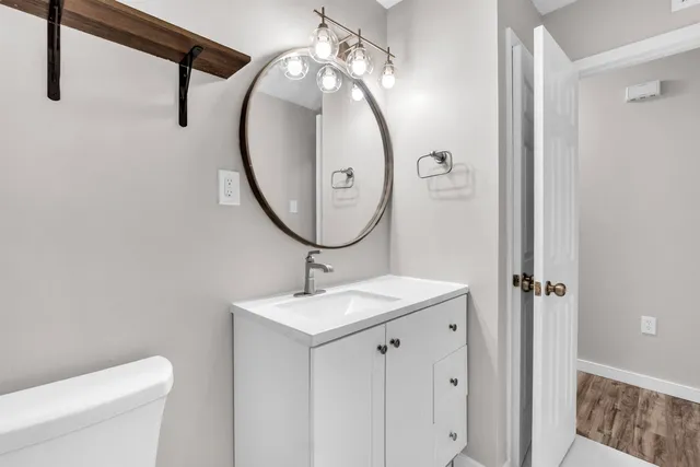 a bathroom with a sink a toilet and a mirror