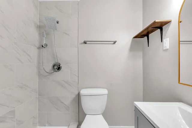 a bathroom with a sink a toilet and shower