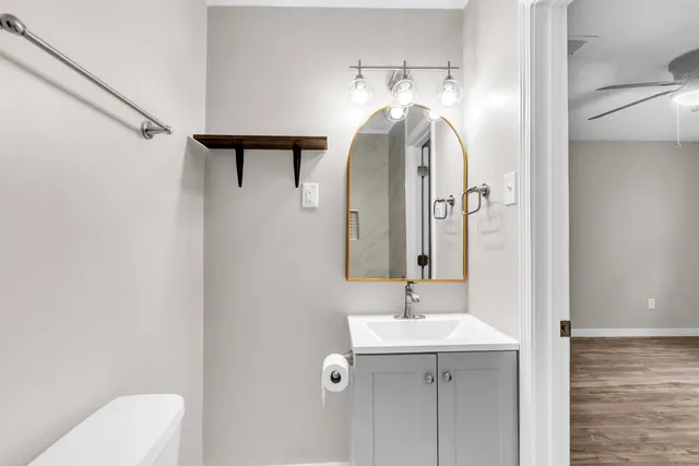 a bathroom with a sink a toilet and mirror