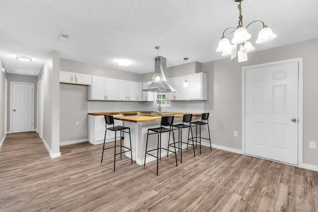 a kitchen with stainless steel appliances granite countertop a kitchen island a stove a table and chairs in it