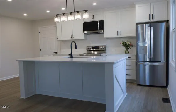a large kitchen with a wooden floor and a fireplace