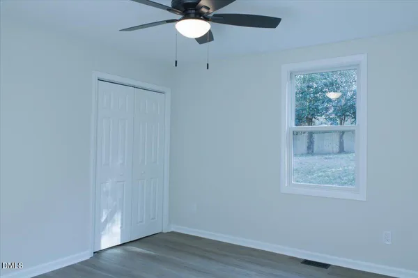 a view of an empty room with wooden floor
