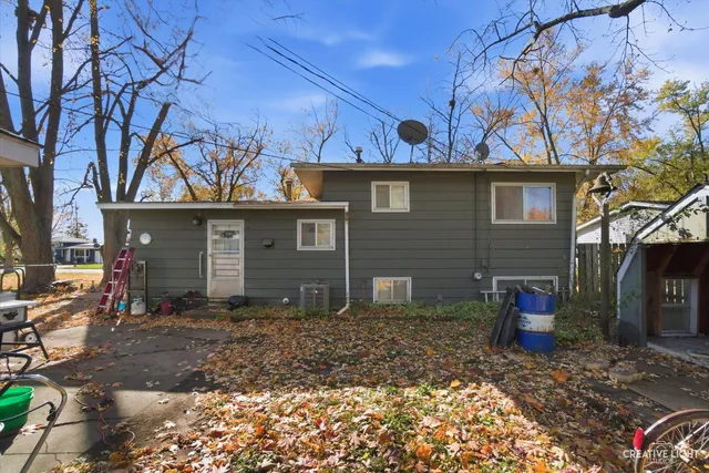 a view of a house with a yard next to a large tree