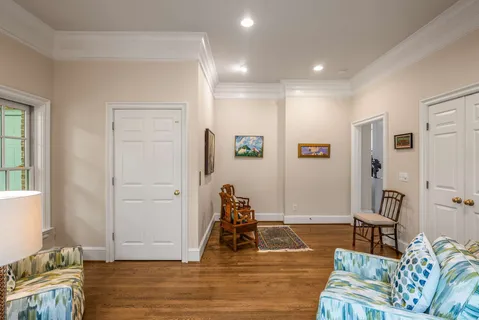 a living room with furniture large window and wooden floor