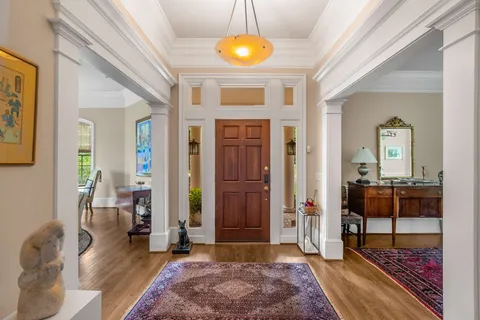a living room with furniture a dining table and large windows