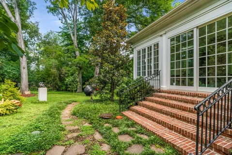an aerial view of residential house with outdoor space and trees all around