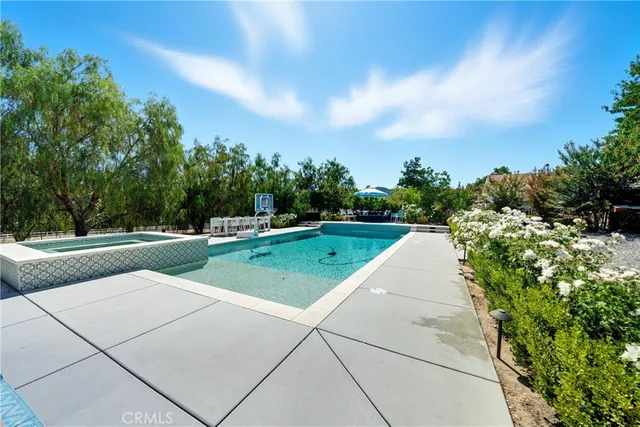 a front view of a house with a yard garden and swimming pool