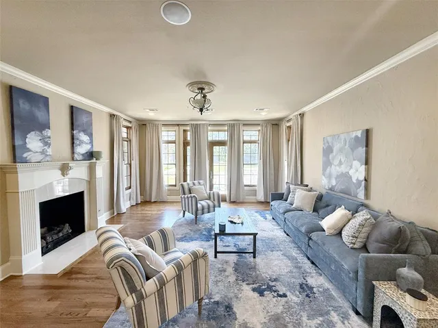 a living room with furniture fireplace and a large window