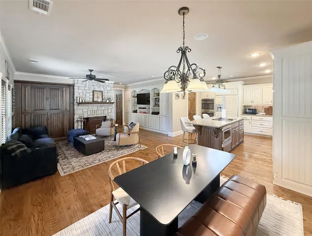 a living room with furniture kitchen view and a wooden floor