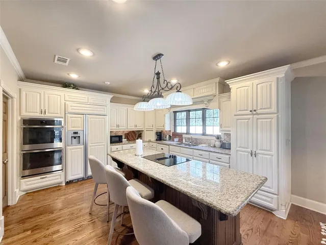 a kitchen with kitchen island a refrigerator stove microwave and cabinets