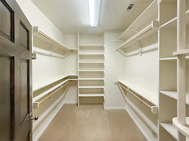 a view of walk in closet with empty racks
