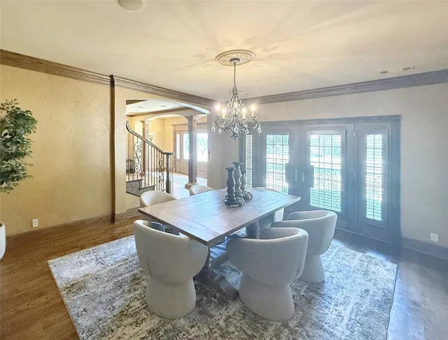 a dining room with wooden floor and a chandelier