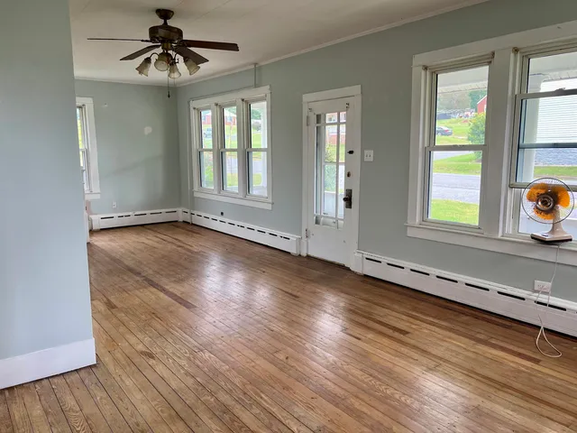 a view of a room with wooden floor and a bathroom