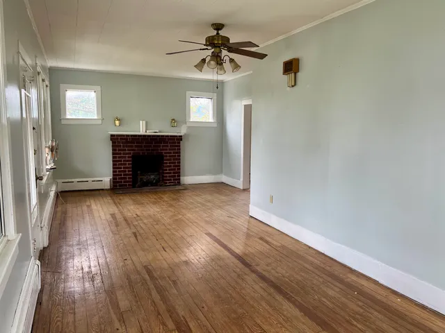 an empty room with wooden floor and window